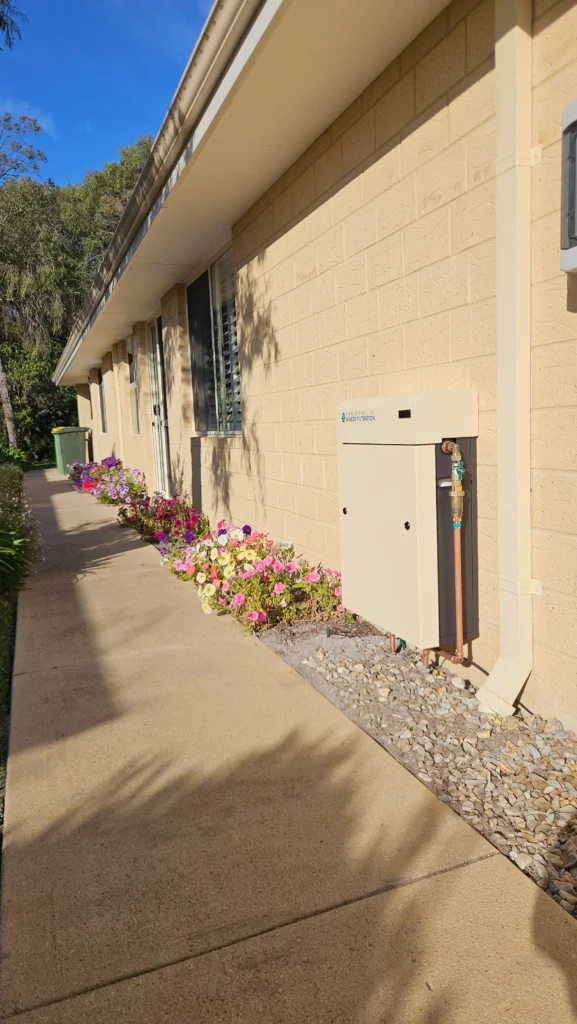 Classic Cream whole-home water filter blending in with the brickwork of a Dunsborough home