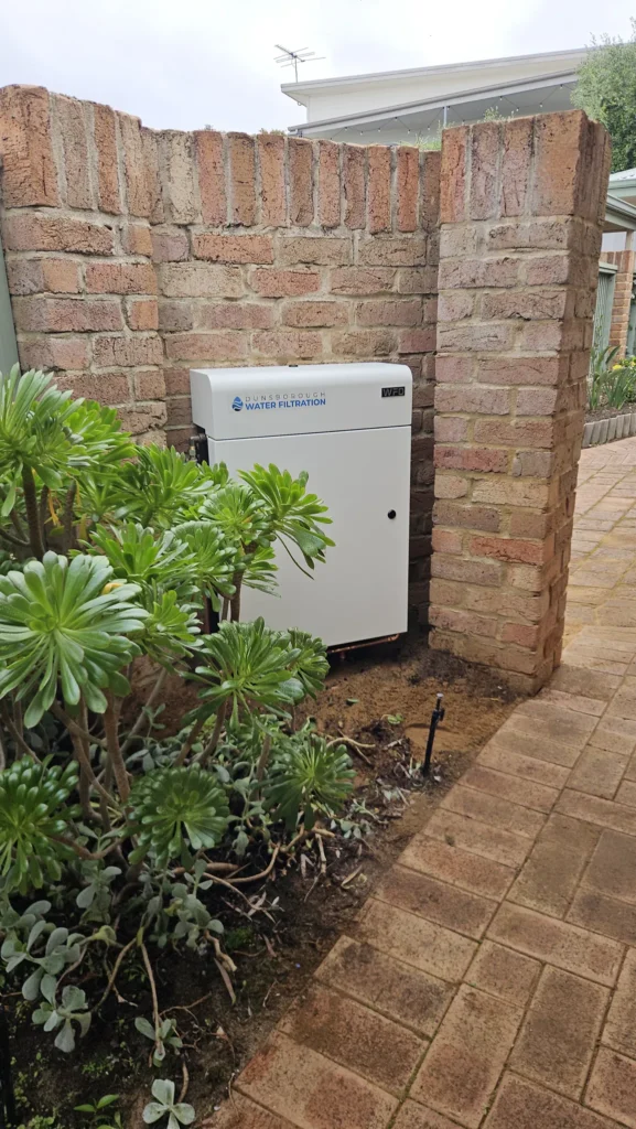 Vortex Pro 3 whole-home filter set into a brick courtyard wall