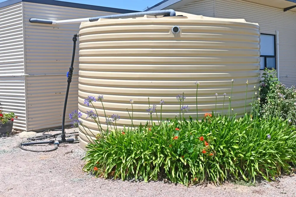 Plastic water storage tank on the side of a house